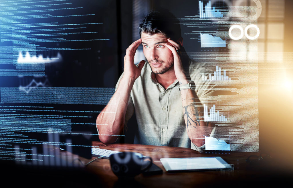Stressed-out programmer working on code at night; programmer trying to make a decision on software rewrites.