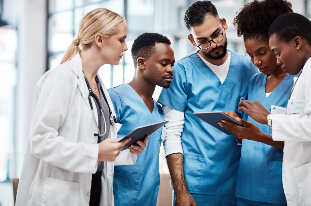 A group of young doctors using a tablet; custom software solutions for the healthcare industry.
