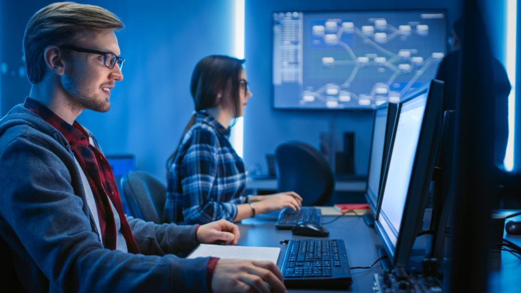 IT specialists working in a data center technician room; modernize your legacy system with a state-of-the-art IT center..